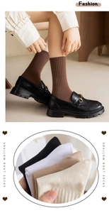 Détail de chaussettes mi-hautes en coton côtelé aux tons Morandi avec revers élastiques