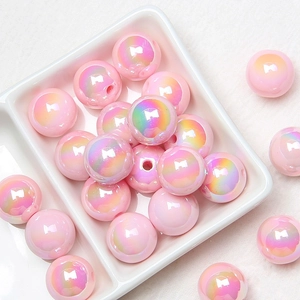 Detailed view of pink iridescent acrylic round beads in a tray for DIY jewelry making