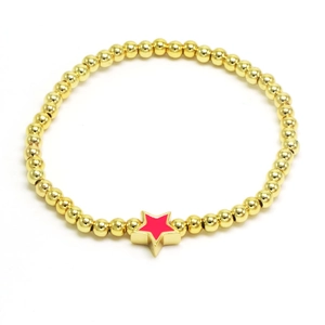 Minimalist gold beaded stretch bracelet with a vibrant red star pendant charm