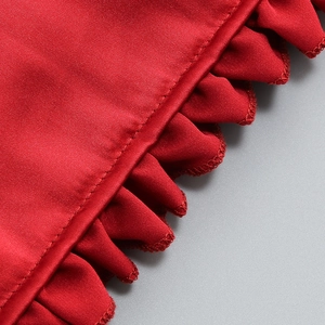 Detaillierte Nahaufnahme roter Satin-Volants mit elegantem Glanz am schmalen Minikleid