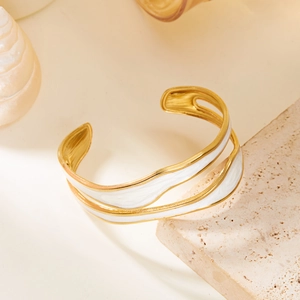Detail view of double-layer wave gold bangle with white enamel inlay and open cuff