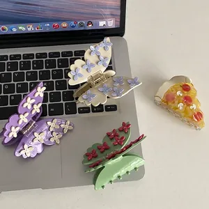 Floral butterfly hair claws and creative pizza hair clip set on a modern desk