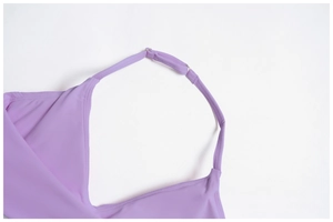 Detail of adjustable metal buckle and flatlock stitching on purple yoga top straps
