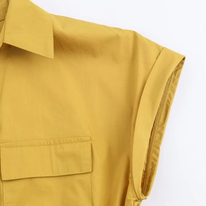 Détail d'une robe midi en popeline jaune gingembre avec col à revers et poche poitrine