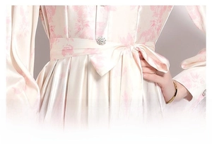 Detail of adjustable lace-up waist on a floral satin dress with elegant pink patterns