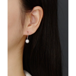 Close-up of S925 silver sunflower earrings with sparkling center stone on model ear