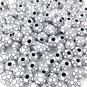 Detailed pile of black and white star patterned soccer ball acrylic beads for DIY crafts