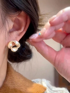 Detailed close-up of 14K gold plated flower earring with pearls and sparkling crystals