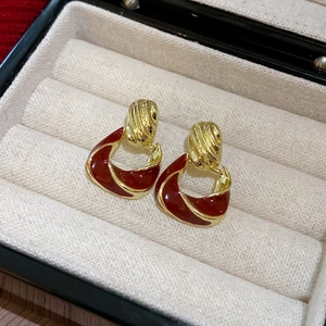 Macro detail of vintage red enamel and gold geometric earrings in a jewelry box