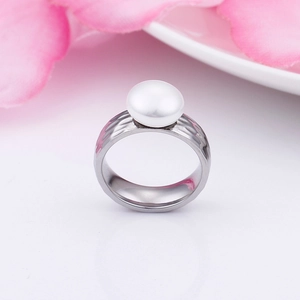Close-up of hammered stainless steel ring with a round white pearl on a floral backdrop