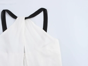 Détail du tissu texturé blanc avec bretelles noires et coutures côtelées visibles