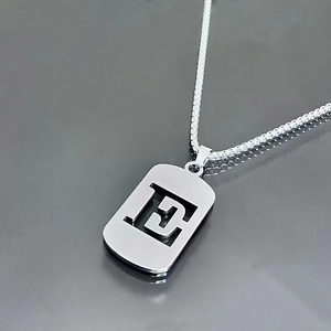 Macro shot of silver hollow letter pendant and durable titanium steel box chain