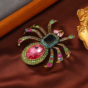 Retro spider brooch with pink oval crystal and colorful rhinestones on silk background