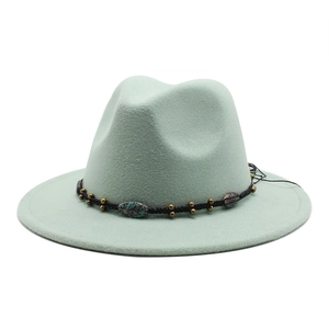 Detail of mint green fedora hat featuring a black woven band with bronze metal beads