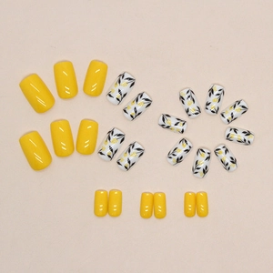 Yellow and white square press-on nails with leaf patterns and minimalist floral design