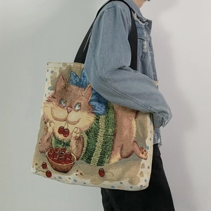 Detail of printed canvas tote bag featuring cute orange cat and cherry patterns