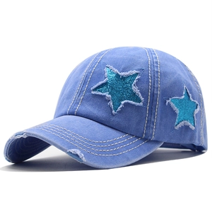 Détail d'une casquette de baseball en coton délavé bleu avec patchs étoiles scintillantes
