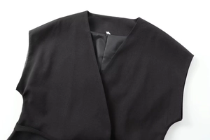 Détail du gilet noir à col en V profond avec doublure lisse et ceinture assortie