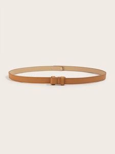 Detail of tan adjustable narrow waist belt with metal buckle and cross-grain texture