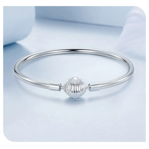 Detailed view of silver metal bracelet featuring a delicate shell-shaped clasp and ocean style