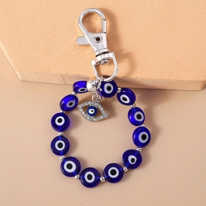 Macro shot of evil eye keychain with blue beads and rhinestone palm pendant charm