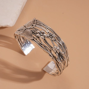 Vintage oxidized silver cuff bracelet with intricate butterfly and floral vine patterns