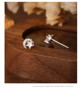 Macro shot of S925 silver moon and star earrings with sparkling cubic zirconia inlay