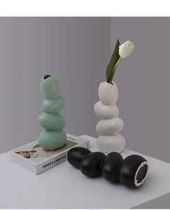 Detail showing smooth ceramic texture and anti-slip bottom pads on pebble vases