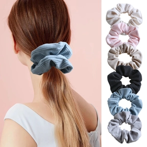 Detailed view of textured waffle scrunchies in six colors and side hair styling look