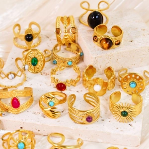 Vintage 14k gold plated stainless steel rings with colorful gemstones on stone display