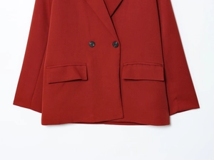 Detail of red double-breasted blazer showing fine fabric texture and button closure