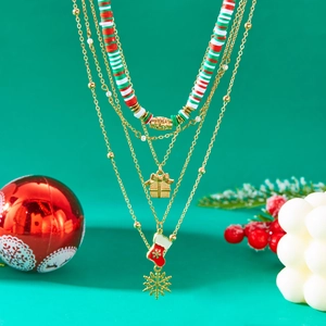 Detail of layered Christmas necklace featuring clay beads, gift box, and stocking charms