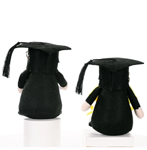 Rear view detail of two graduation plush dolls with black academic gowns and mortarboards