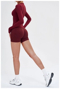 Détail d'un ensemble de yoga bordeaux avec short taille haute et haut court à manches longues