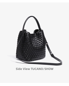 Side view detail of black woven bucket bag showing premium leather texture and strap