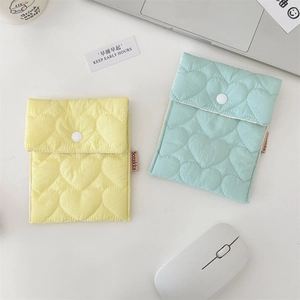 Quilted heart pattern sanitary storage bags in yellow and blue colors on a clean desk