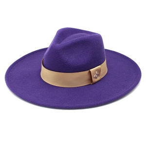 Detailed close-up of a purple wool fedora hat featuring a gold ribbon and bee ornament