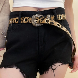 Détail de la ceinture léopard avec œillets dorés et boucle vintage sur un short noir