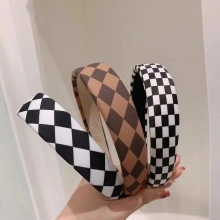 Close-up of fabric headbands in black and brown argyle and checkered patterns