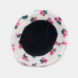 Détail d'un bob en peluche à fleurs montrant la doublure noire et le cordon réglable