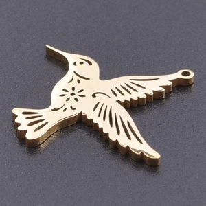 Macro view of golden hollow-out stainless steel hummingbird pendant for jewelry DIY