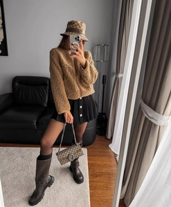 Giacca in pile marrone con zip abbinata a gonna a pieghe nera e accessori moda di tendenza