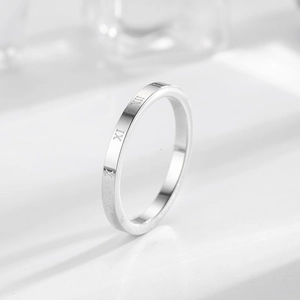 Anello in acciaio inossidabile lucido con numeri romani incisi su uno sfondo bianco