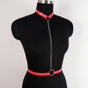 Red leather harness set with silver metal chains on black mannequin for bondage use