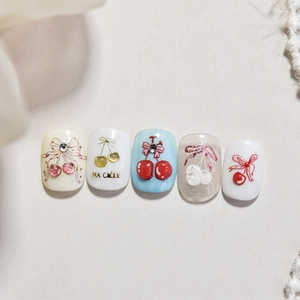 Macro detail of gold cherry and bow nail stickers with rhinestones and 3D textures