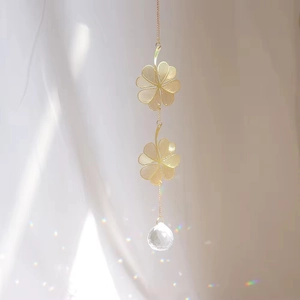 Detailed view of golden lucky clover suncatcher reflecting rainbow light spots