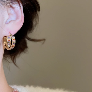 Close-up of model wearing 18K gold plated hoop earrings with colorful zircon stones