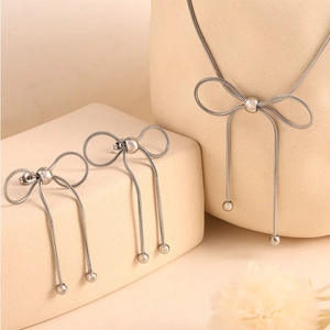 Silver butterfly jewelry set with tassel snake chains on a premium display stand