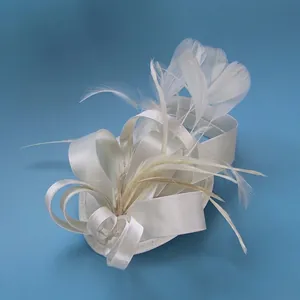 Detail of elegant cream fascinator hat featuring satin bows and delicate feathers