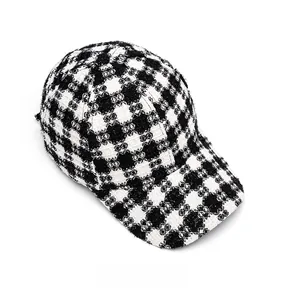 Top-down macro view of black and white plaid textured tweed fabric on a baseball cap